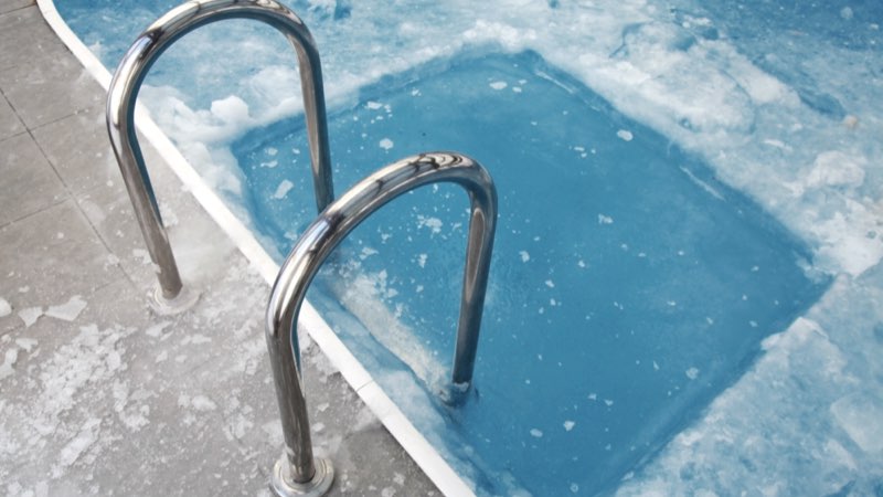 Vereister Pool mit Einstiegsleiter im Winter
