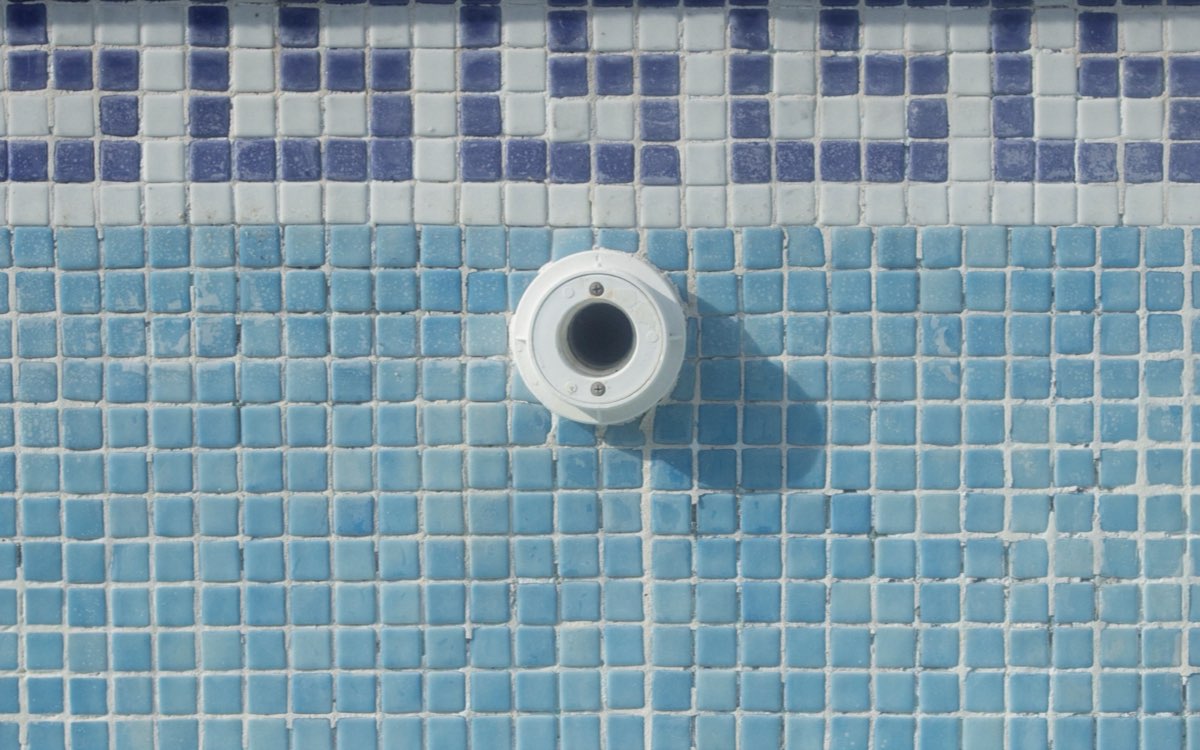 Pool-Einlassarmatur in der gefliesten Beckenwand