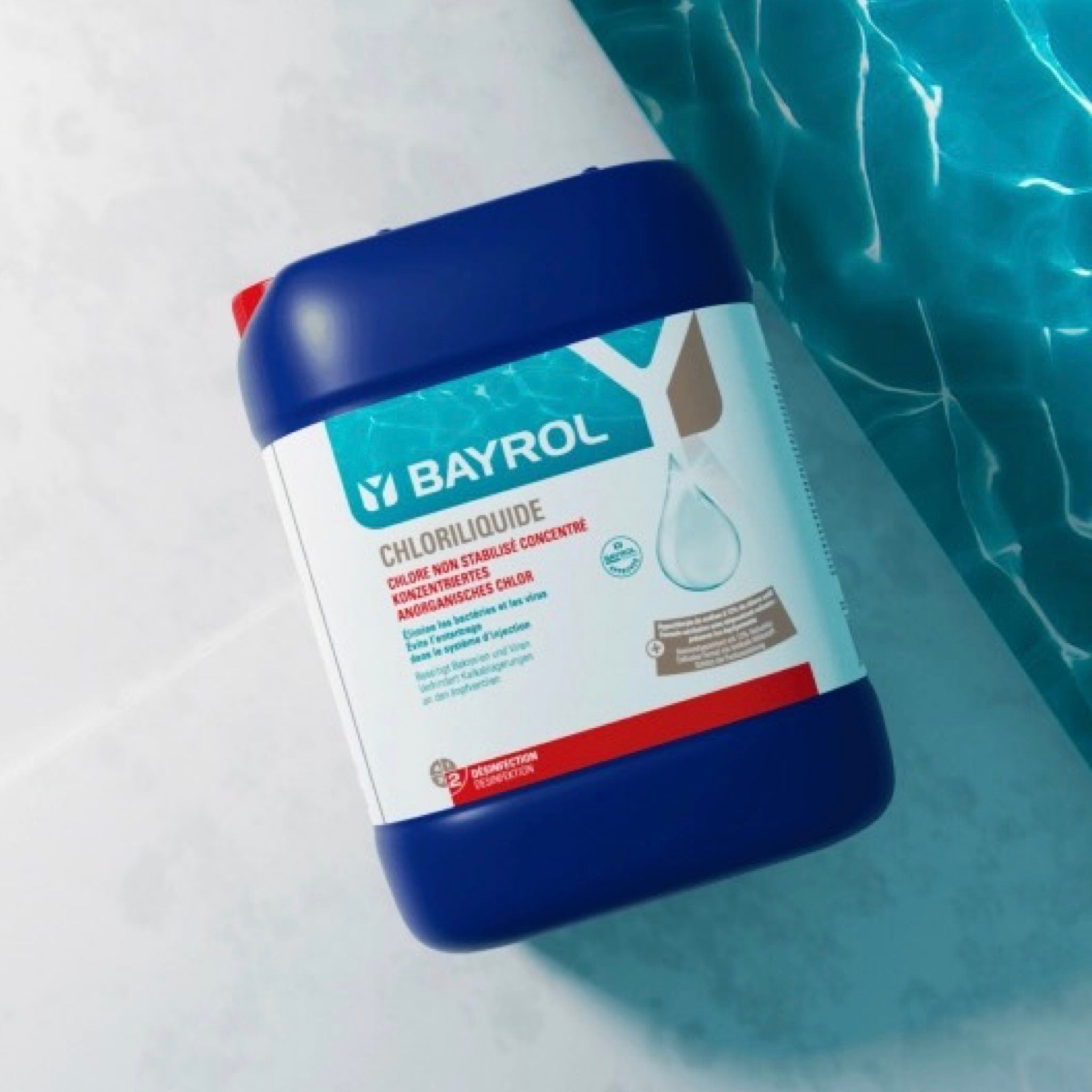 BAYROL Chloriliquide – Kanister am Poolrand mit blauem Wasser im Hintergrund