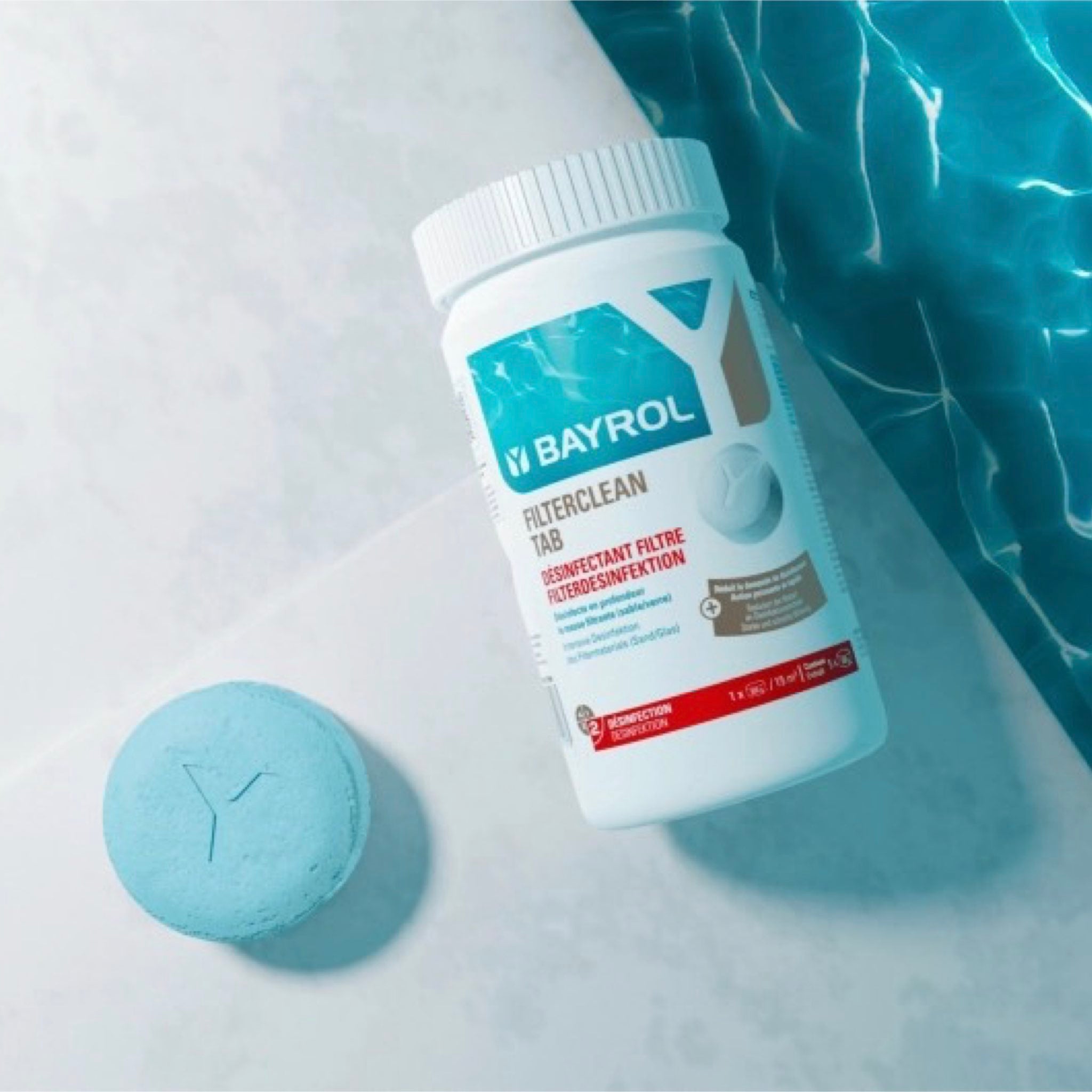 BAYROL Filterclean Tab 1 kg – Dose und blaue Tablette am Poolrand neben Wasser